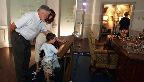 Visitors use the Oval Office desk interactive at the Library's new permanent exhibit